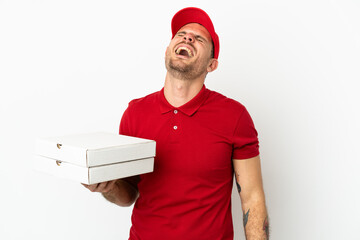 pizza delivery man with work uniform picking up pizza boxes over isolated  white wall laughing