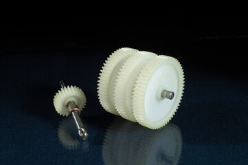A white plastic gear on a table with a reflection.
