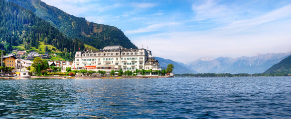 Beautiful view from the lake to the promenade of Zell am See, Austria - obrazy, fototapety, plakaty