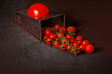 Large and small fruits of tomatoes on black background