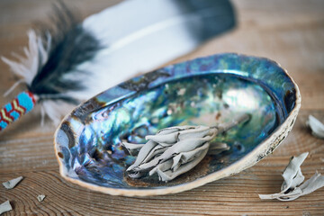 Weißer Salbei wird in einer Abalone geräuchert - spirituelle Raumreinigung