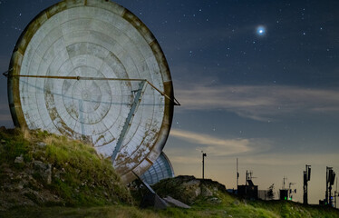 NATO satellite dishes with starry sky and planet Jupiter