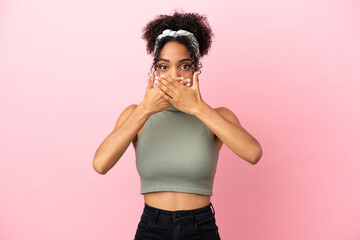 Young latin woman isolated on pink background covering mouth with hands