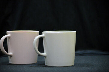 A grey and pink cup or mug on a back background