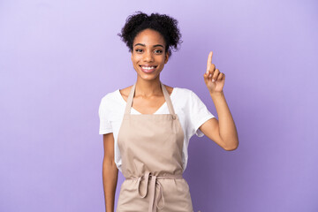 Restaurant waiter latin woman isolated on purple background pointing up a great idea