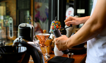 Barista grinding coffee beans for drip brew