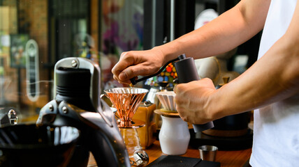 Fototapeta na wymiar Barista grinding coffee beans for drip brew