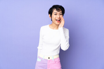 Young Vietnamese woman with short hair over isolated purple background shouting with mouth wide open