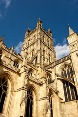 Gloucester Cathedral looking up at the tower against a blue sky.