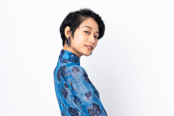 Young Vietnamese woman with short hair wearing a traditional dress over isolated white background