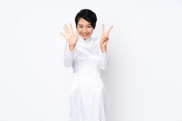 Young Vietnamese woman with short hair wearing a traditional dress over isolated white background counting seven with fingers