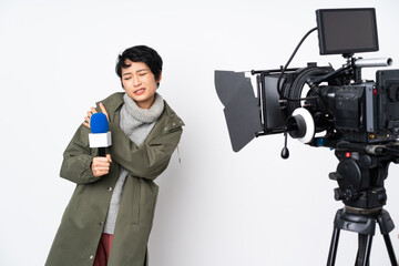 Reporter Vietnamese woman holding a microphone and reporting news suffering from pain in shoulder for having made an effort