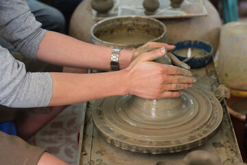 hands of a male artisan making a potter.