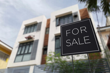 For sale sign in front of an affordable three storey apartment building. A medium density...