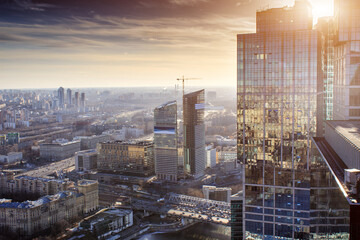 view from the roof of a skyscraper to sunset and other skyscrapers in Moscow / facade of a skyscraper with reflection in the glass