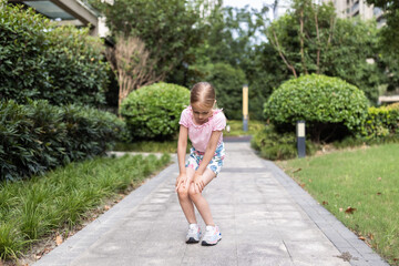 Fototapeta na wymiar Cute little caucasian Girl with blonde hair Stretching outdoor on backyard Before Running
