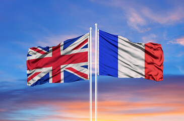 Two waving state flags of United Kingdom and France on the blue sky. High - quality business background