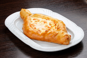 Khachapuri with shrimp and cheese. On a wooden background