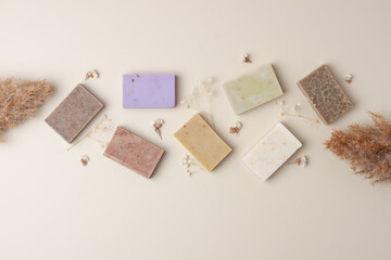 Soap and flower on beige background. Flat lay, copy space.