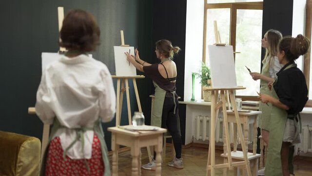 Group of students painting at art lesson in studio