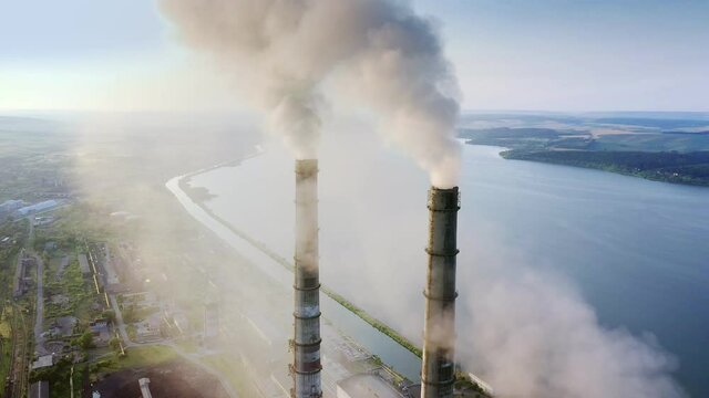 Aerial view of coal power plant high pipes with black smokestack polluting atmosphere. Electricity production with fossil fuel concept