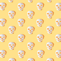 Halloween skeleton masks with sunshine shadows on bright yellow background. Minimal autumn holiday pattern.