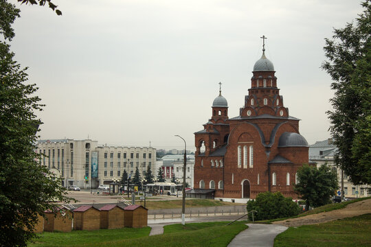 Vladimir, Russia - AUGUST, 11, 2021: the historical building of the museum of crystal and glass made of red brick with gray domes in the old town on a cloudy day and green foliage of trees