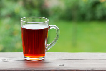 A cup of tea on the balcony railing on a summer morning. Selective focus.