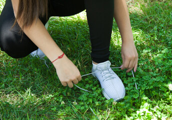 Fototapeta na wymiar Woman runner tying her sneakers shoes. Outdoors.