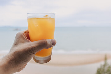 Fresh juice in a glass with sea view background in concept of summer.