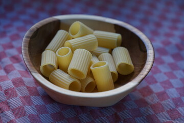 a wooden bowl with rigatoni in it