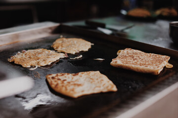 Close up details of Asian street food: toasting pancakes