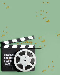 composition with film strip, clapperboard and confetti gold stars on green background. concept...