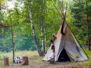 Forest home of the Indians. Wigwam indian teepee. The life of nomadic tribes. The wigwam stands in the forest. A hut of nomadic peoples. A home of Indians. tippi aka in the forest.