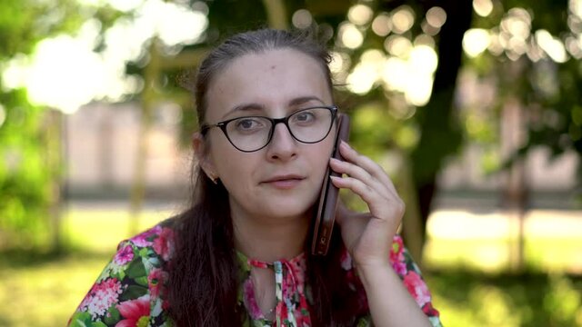 a girl with glasses talking on the phone