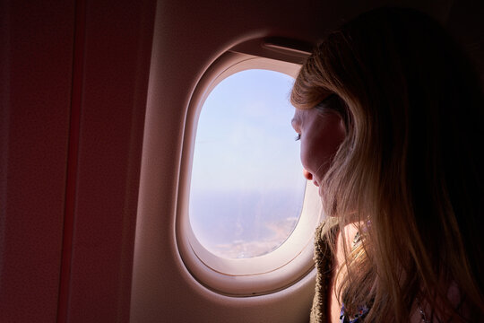 Girl Looking Out The Plane Window