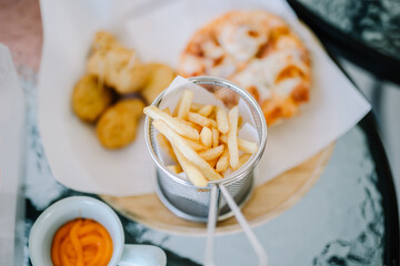 Fresh fried french fries with ketchup on wooden background