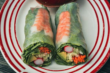 Summer rolls of shrimp, carrot, cucumber, avocado, imitation crab wrapped in green leaf lettuce and tapioca paper © mariekazalia