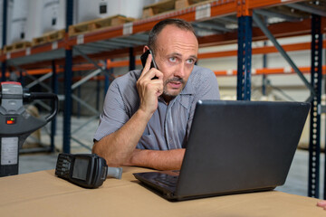 businessman using a laptop in a warehouse