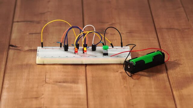 Multivibrator assembled on breadboard board on wooden table.