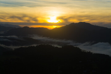 Scenic view of a sunrise over foggy mountain range