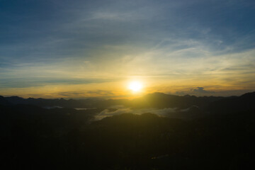 Scenic view of a sunrise over foggy mountain range