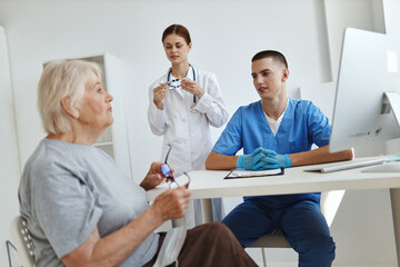 Obraz premium elderly woman patient at doctor's appointment and nurse in office