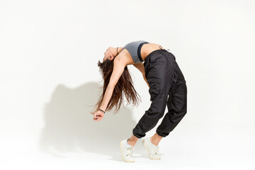 Agile supple young woman doing a modern hip hop dance pose