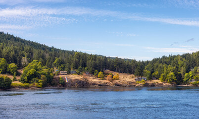 Fototapeta premium View of a Cosy Homes on the rocky coast during a sunny summer day. Taken on Galiano Island near Vancouver Island, BC, Canada.