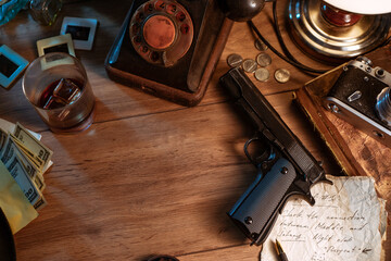 Private detective's desk, noir still life with a vintage phone, typewriter, lamp, gun and retro photos