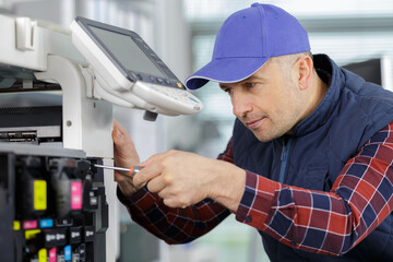 a man fixing photo copier
