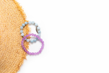 Marine women's bracelets made of natural stone. Straw hat. White background.