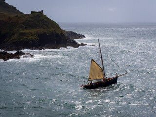 A sailing boat exiting the estuary into the English Channel at Fowey in Cornwall