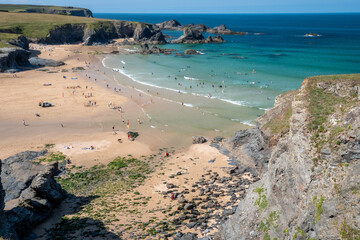 Fototapeta na wymiar Looking down from the cliffs at the beach at Cornwall's Porthcothan bay on beautiful summer's day